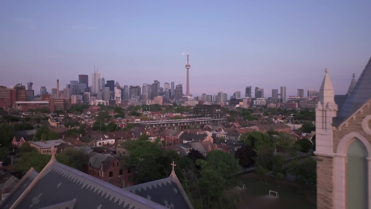 대도시의 시내를 바라보는 드론 항공기 교회 타워를 지나 날아갑니다.