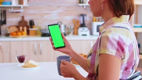 Woman-reading-on-phone-with-green-screen