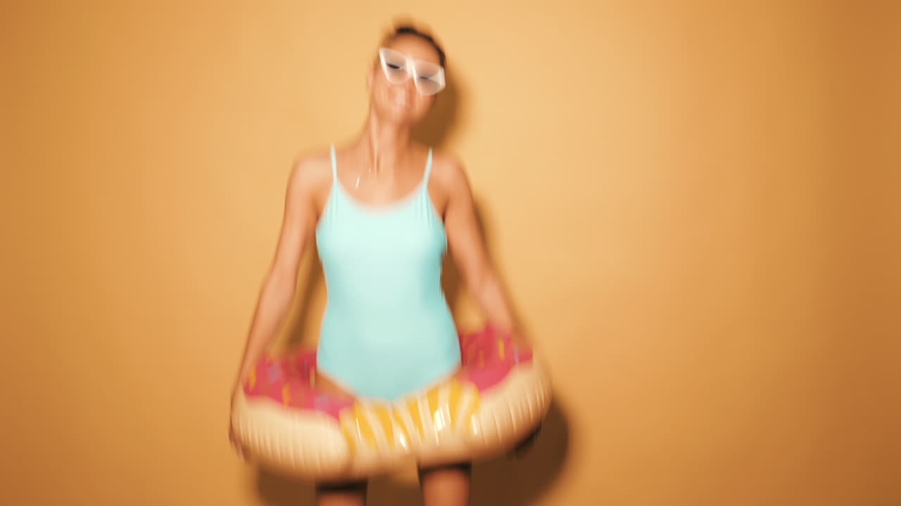 mujer en traje de baño con rosquilla inflable