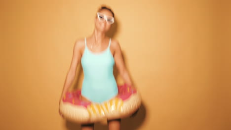 woman in swimsuit with donut inflatable