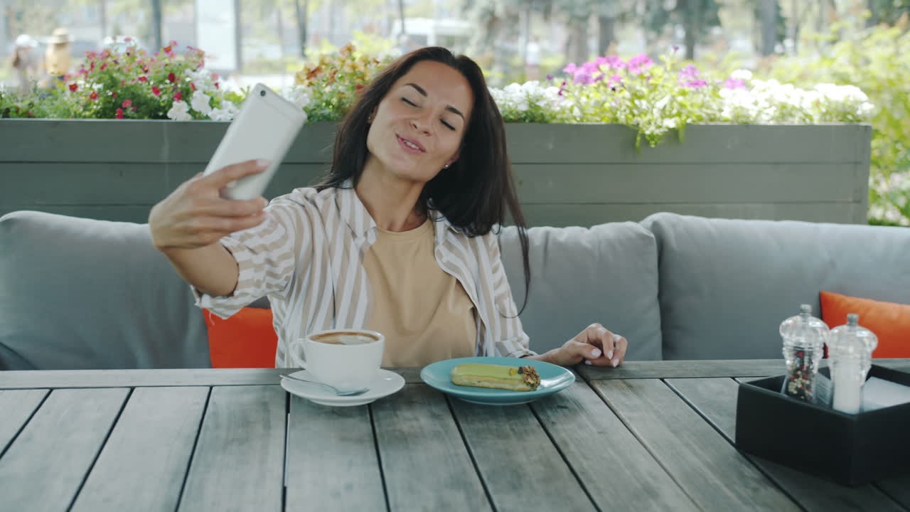 Woman taking selfies in a cafe