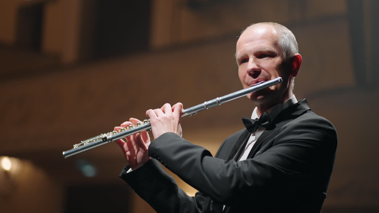 은 음악 홀이나 오페라 하우스 무대에서 플루트를 들고 있는 노인 초상화.