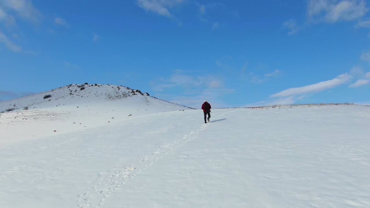 푸른 얼어붙은 하늘을 향해 눈 인 경사선을 따라 고 있는 사람의 모습