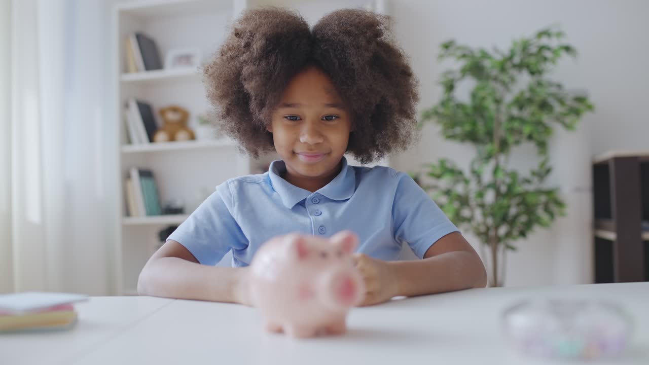 Excited little girl putting coins into piggy bank, saving for something special