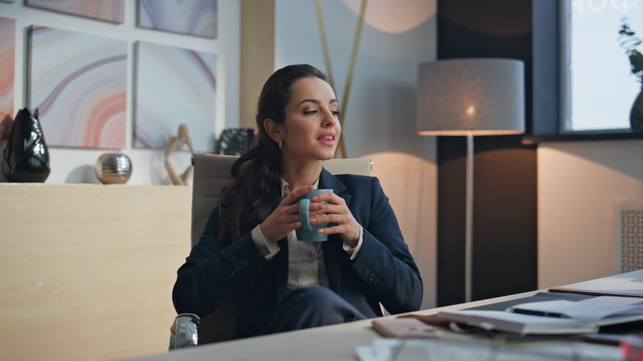 Relaxed lady drinking coffee enjoying break with closed eyes at cozy armchair