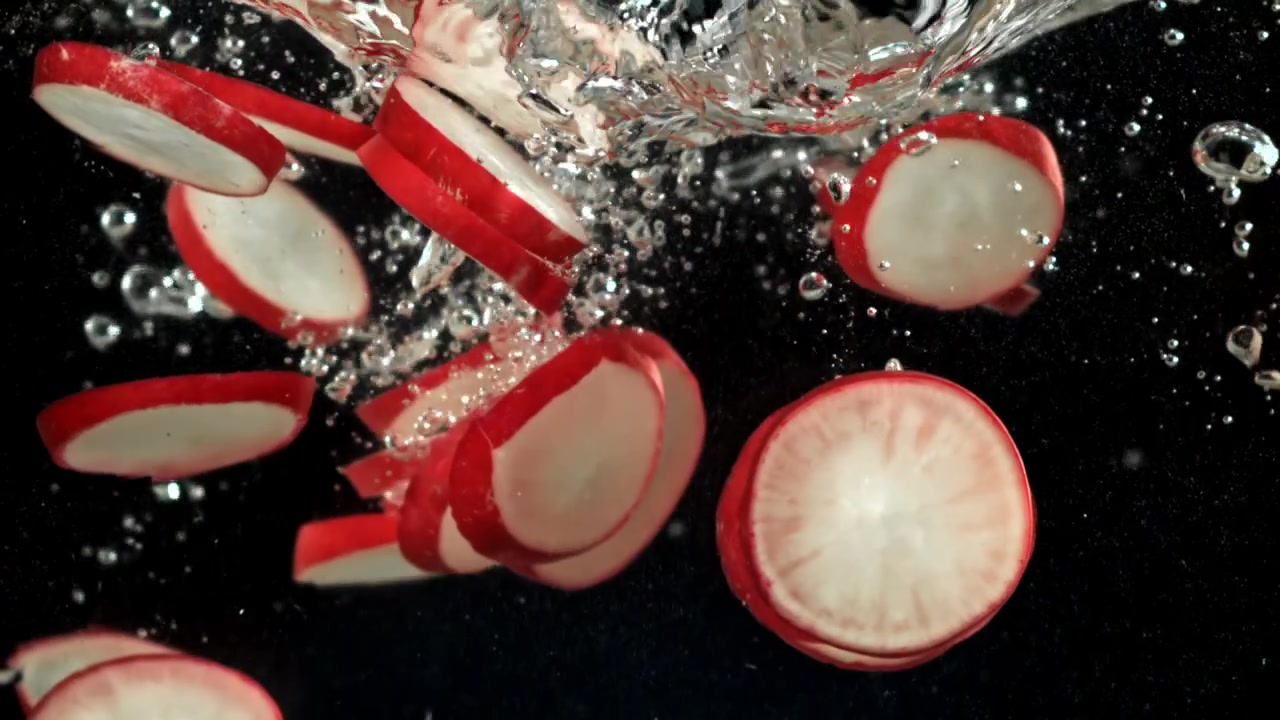 Fresh Sliced Radishes Dropping into Water in Slow Motion