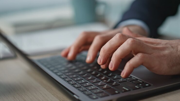 Managerhände tippen Bericht am Laptop am Arbeitsplatz, Nahaufnahme. Lächelnder Geschäftsmann.