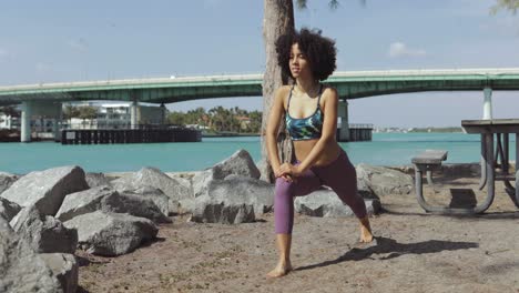 black sporty girl warming up in park