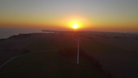 drone aerial view of wind energy generator power plant with yellow sun background
