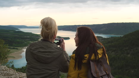 two women enjoying the sunset view from a mountaintop