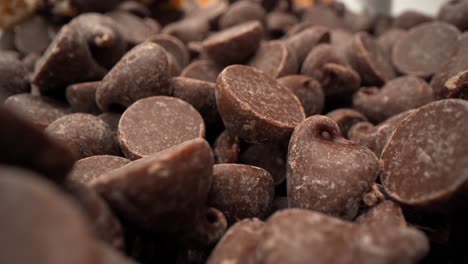 chocolate chip tower with cookie pieces and chocolate chips falling macro close up pull away 4k food product video