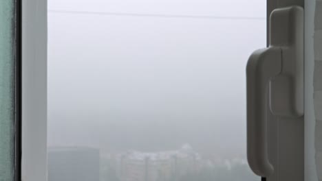 사람이 비가 오는 날씨에 창을 열고 닫습니다. 클로즈업