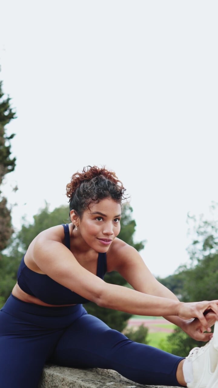 Young Woman Stretching Her Leg Outdoors in Sportswear