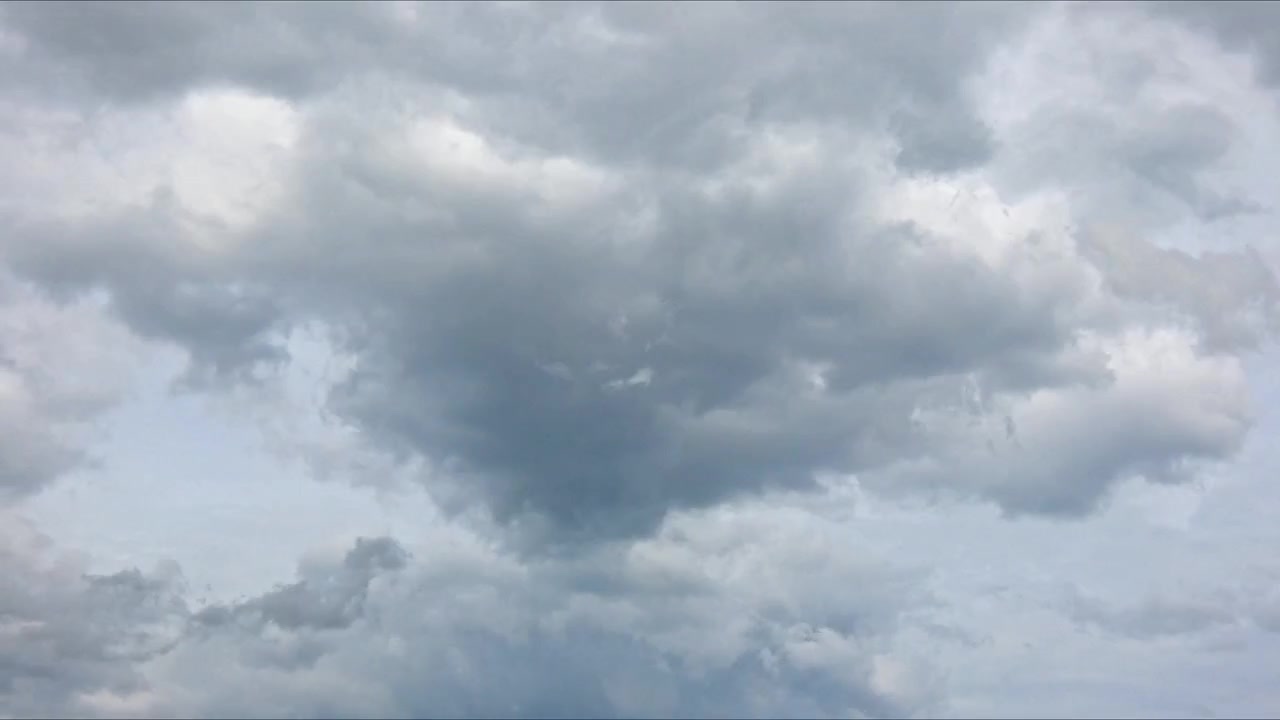 Timelapse of fluffy clouds drifting across a bright blue sky, capturing changing shapes, natural movement, atmospheric beauty, and peaceful daytime scenery.
