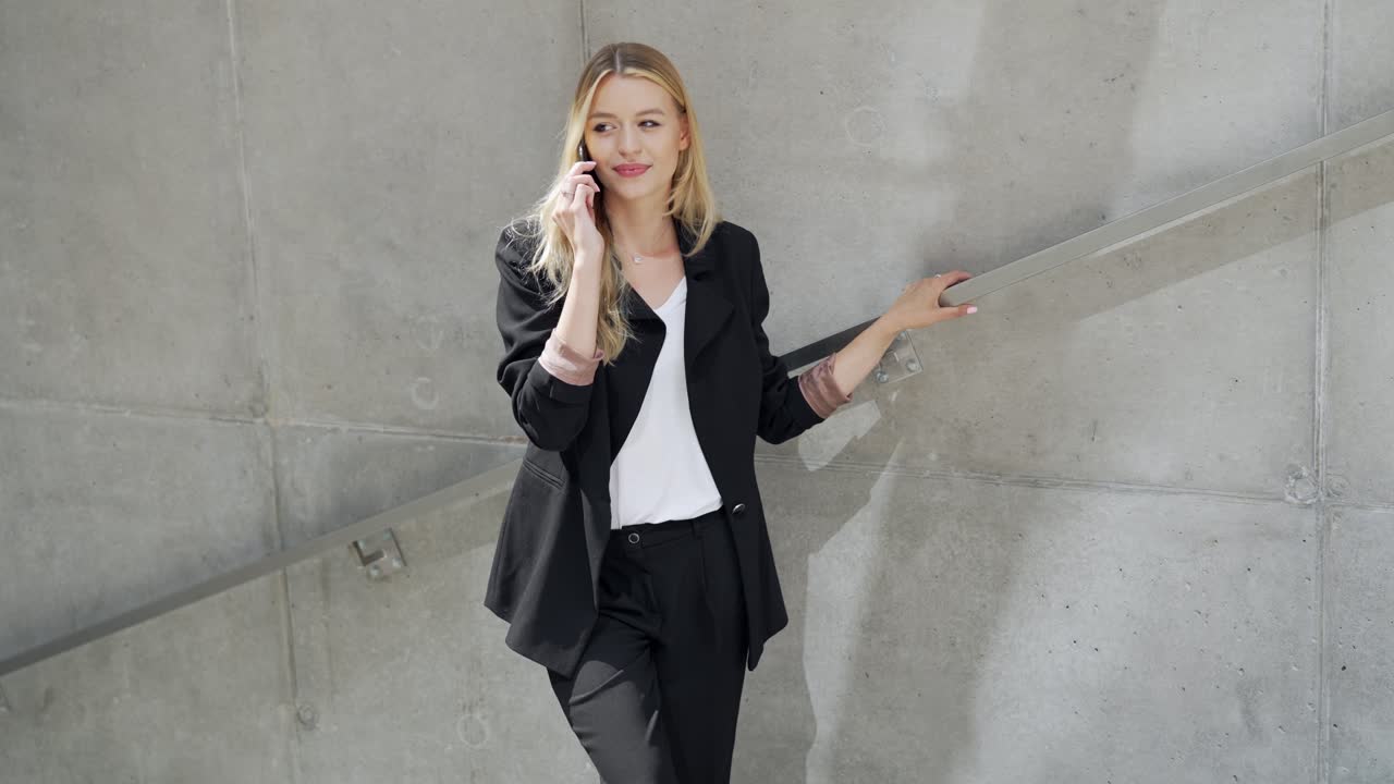 사업가 여성이 야외에서 전화로 이야기하고 있습니다.