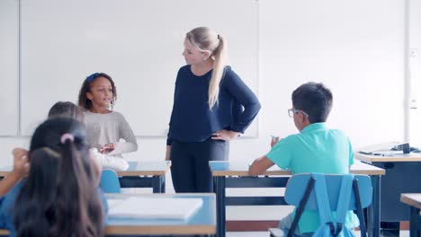 Female-school-teacher-asking-questions-to-mix-raced-pupil