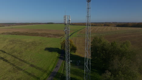 two 5g towers during winter, aerial tilting down