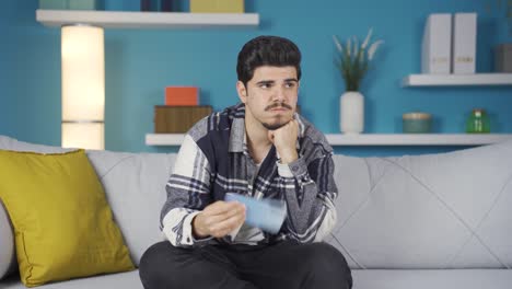 young man looking at the phone in despair and boredom.