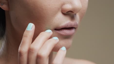 lips of asian woman with dark hair on beige background, slow motion