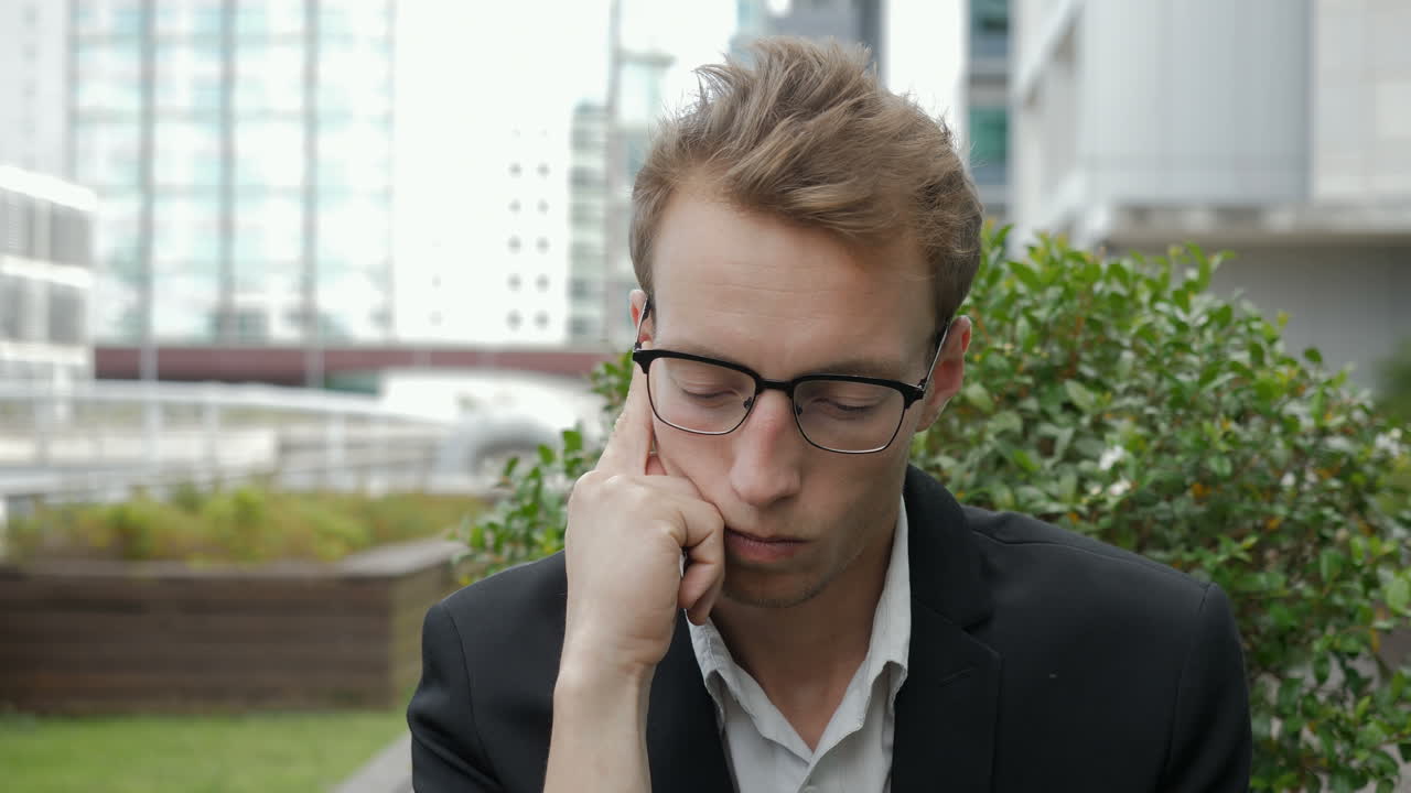 hombre caucásico serio mirando a un lado, tocando la barbilla, pensando