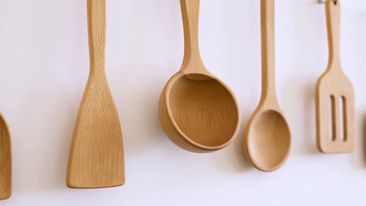 Wooden Kitchen Utensils Hanging on a Clean White Wall