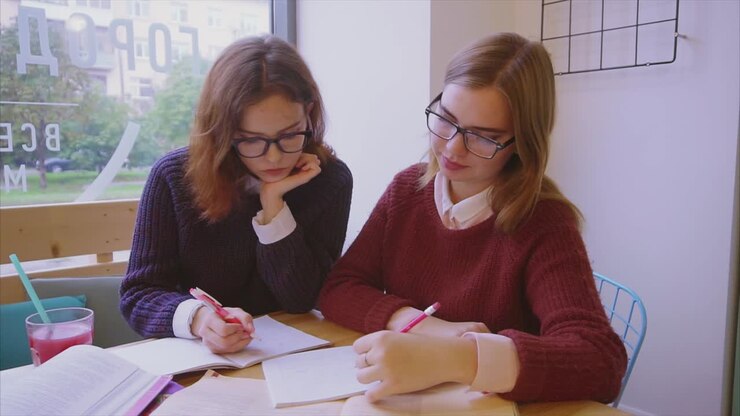 Due ragazze che studiano insieme in un caffè