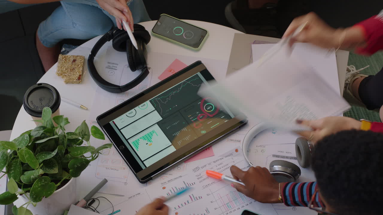 close up hands young engineers developing fitness app software using digital tablet computer brainstorming design solution sharing ideas in startup office meeting top view