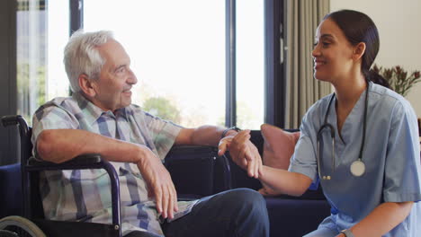 Senior-Caucasian-man-receives-care-from-a-young-biracial-nurse-at-home