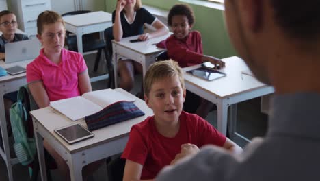 boy raising his hands in the class