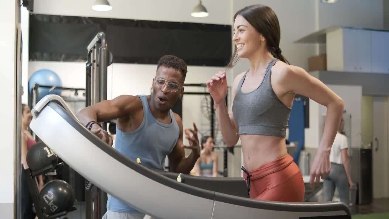 Fitness Trainer Assisting Woman on Treadmill