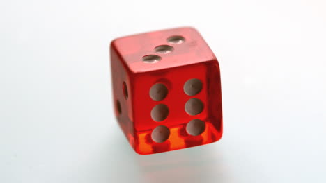 red dice spinning and settling on white surface