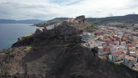 city of castelsardo, certeña: panoramic aerial view of this impressive city built on a mountain and with its colorful houses and its historic tower