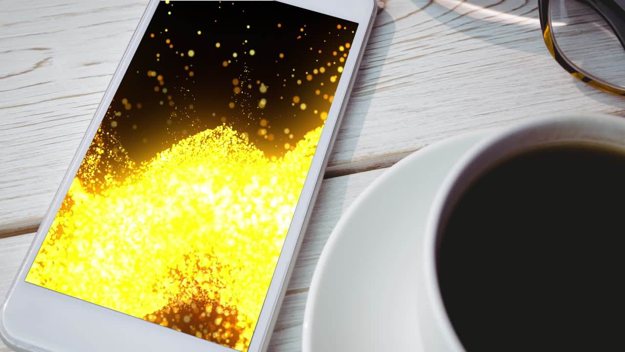 animazione di uno smartphone con tracce di luce sullo schermo e una tazza di caffè sulla scrivania.