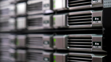 close-up of 4tb hard drives in a server rack, green status lights on