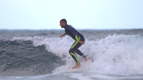 surfista monta una ola en cámara lenta en la playa de gran canaria