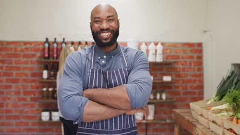 video of happy african american salesman standing in organic grocery shop