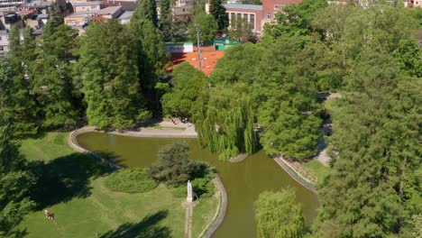 aerial shot descending and circling around danube park in novi sad, serbia on a sunny day