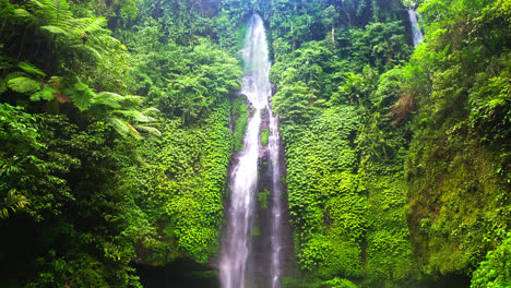Hikers-standing-below-cascading-Fiji-waterfalls-in-jungle-valley,-Bali