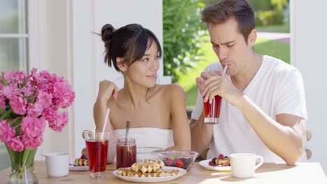 couple drinking iced tea at breakfast outside