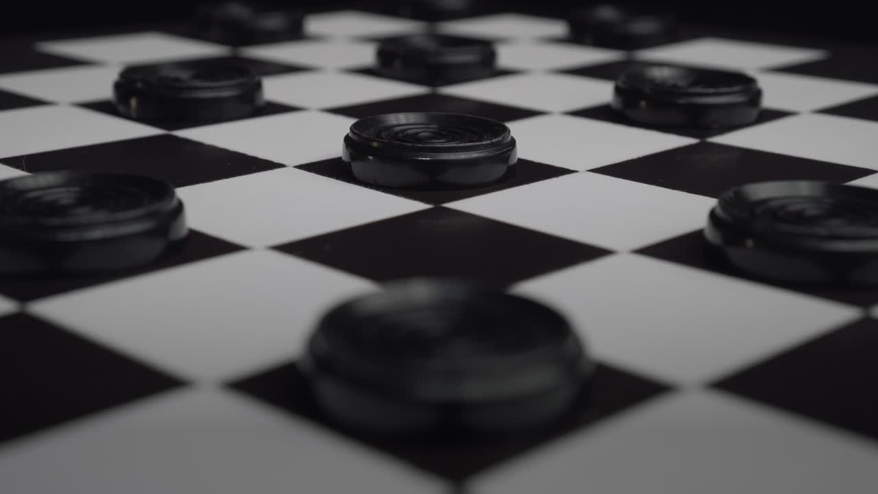 Checkers board with black pieces creating cool light reflections moving back and forth (Draughts)