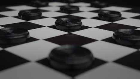 checkers board with black pieces creating cool light reflections moving back and forth (draughts)