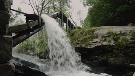 water going through old wooden river mill in strommensaga norway