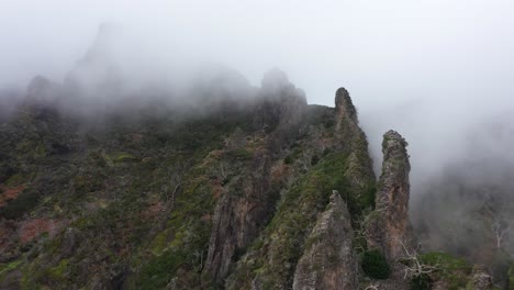 toma de drones del valle de las monjas en madeira, avanzando hacia el borde afilado de la cresta con nubes delgadas y espeluznantes alrededor