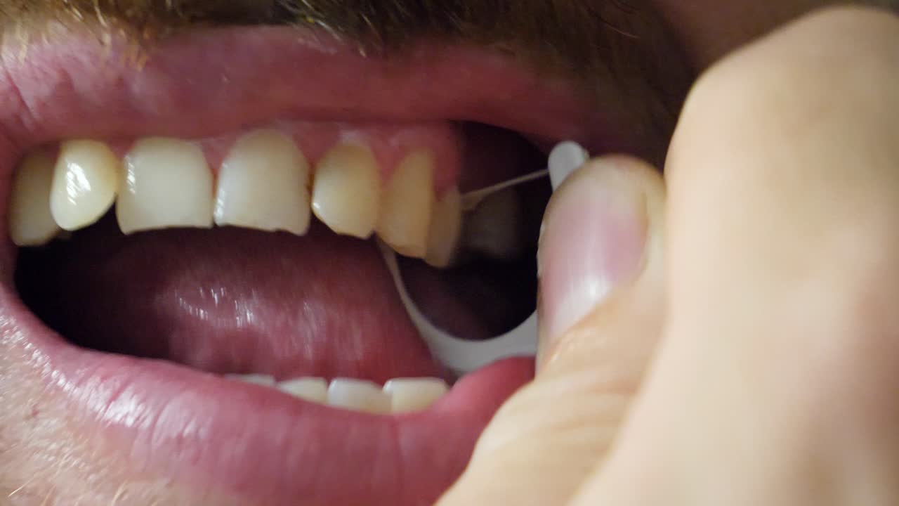 Dental hygiene, Close up of white man flossing his teeth