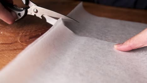 slow motion of cutting tracing paper using scissors close up macro shot