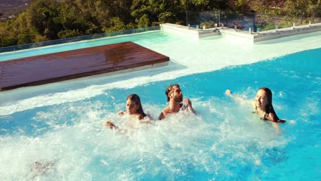 amigos felices saltando en la piscina