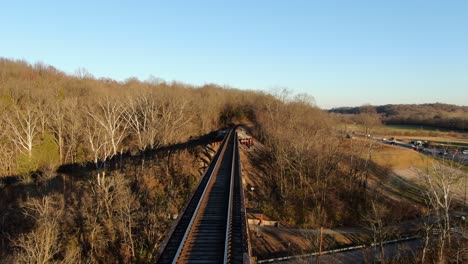 disparo aéreo empujando hacia adelante a lo largo del papa lick caballete de ferrocarril en louisville kentucky durante la puesta de sol