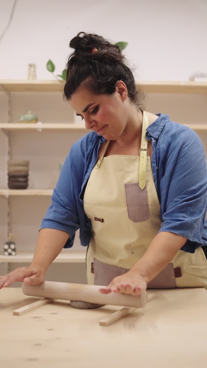 Woman Shaping Clay with Rolling Pin in Pottery Studio