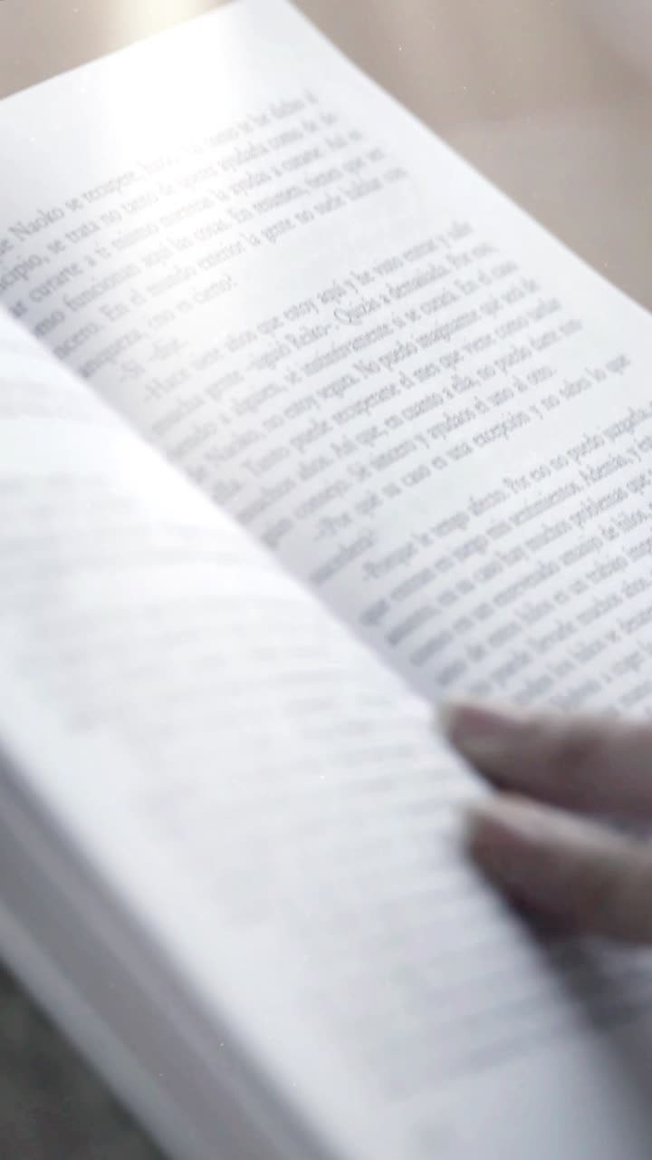 Primo piano di una mano che sfoglia le pagine di un libro