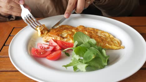 mujer comiendo una tortilla con verduras